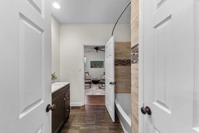 full bathroom with ceiling fan, baseboards, wood finished floors, and vanity