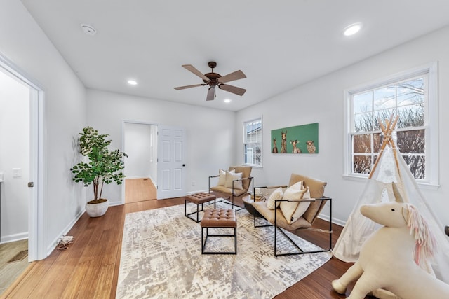 living area with baseboards, ceiling fan, wood finished floors, and recessed lighting