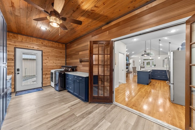 interior space featuring blue cabinets, vaulted ceiling, light countertops, and freestanding refrigerator