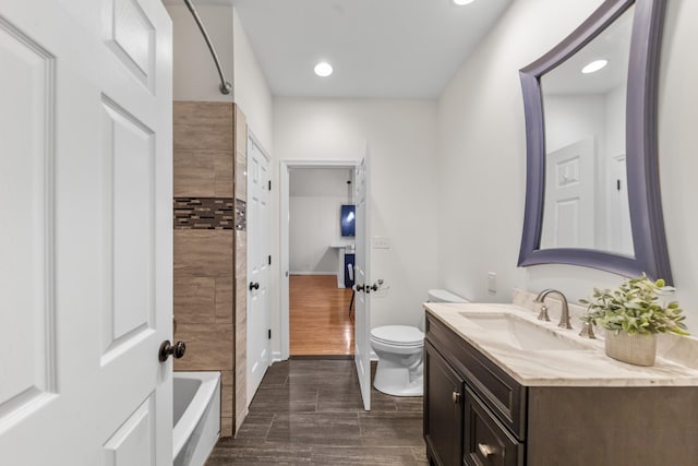 full bathroom with shower / bathtub combination, toilet, vanity, wood finished floors, and baseboards