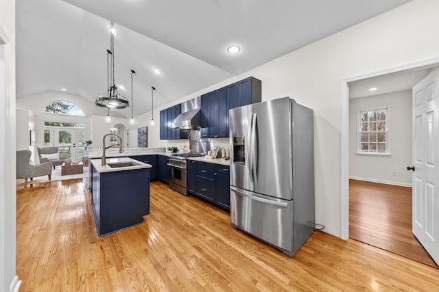 kitchen with wall chimney exhaust hood, blue cabinets, stainless steel appliances, light countertops, and a sink