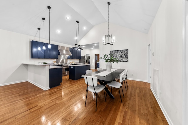 dining space with high vaulted ceiling, visible vents, baseboards, and wood finished floors