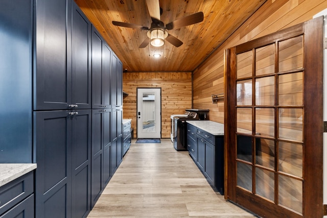 kitchen with light wood-style floors, wood walls, ceiling fan, light stone countertops, and wooden ceiling