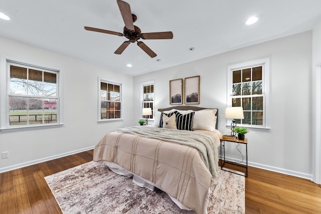 bedroom featuring baseboards, wood finished floors, and recessed lighting