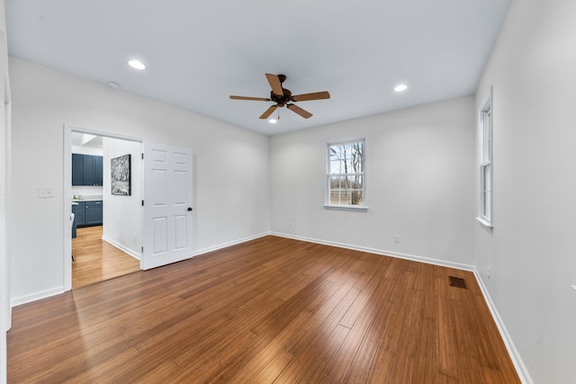 spare room with recessed lighting, visible vents, baseboards, and hardwood / wood-style flooring