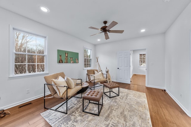 living area with baseboards, visible vents, wood finished floors, and recessed lighting