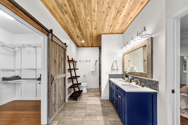 bathroom featuring toilet, wood ceiling, a sink, and wood finished floors