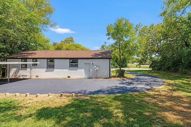 rear view of house featuring crawl space, brick siding, and a yard