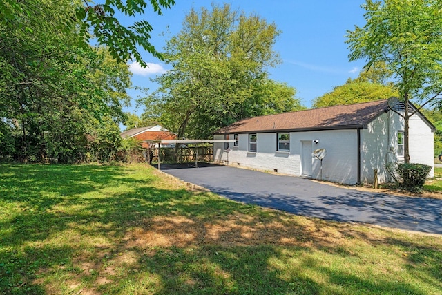 view of front of property featuring aphalt driveway, crawl space, brick siding, and a front lawn