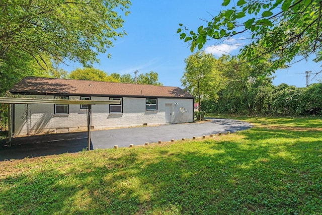 rear view of house with a patio area, brick siding, and a yard