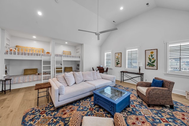 living room with light wood-style floors, recessed lighting, ceiling fan, and high vaulted ceiling