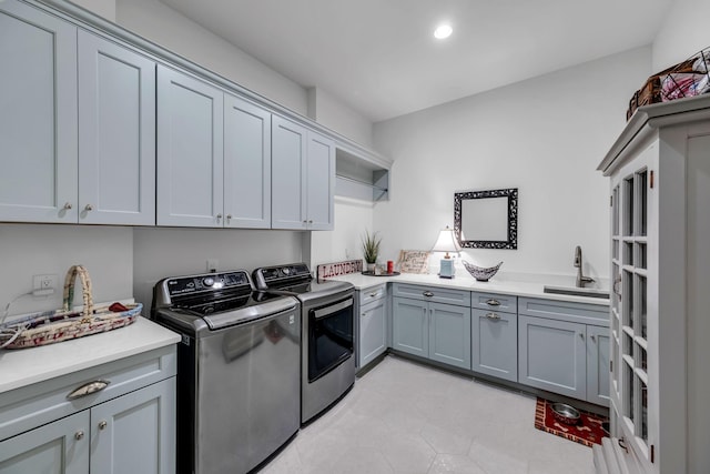 laundry area featuring cabinet space, washer and clothes dryer, and a sink