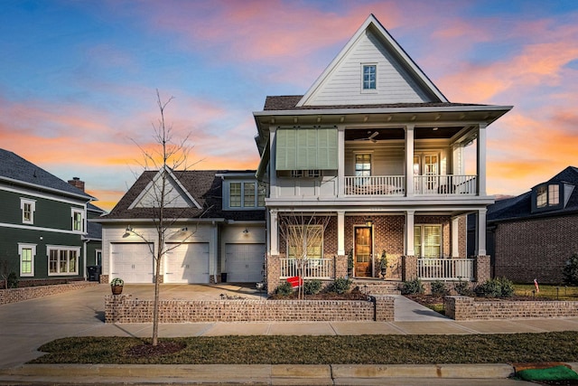 view of front of house featuring brick siding, a porch, a balcony, a garage, and driveway