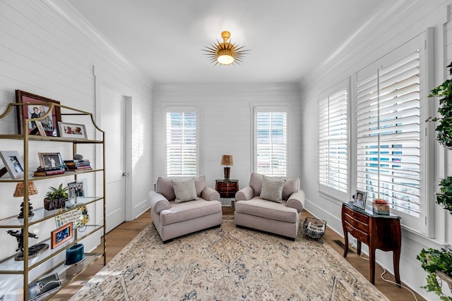 living area with ornamental molding, a wealth of natural light, and wood finished floors