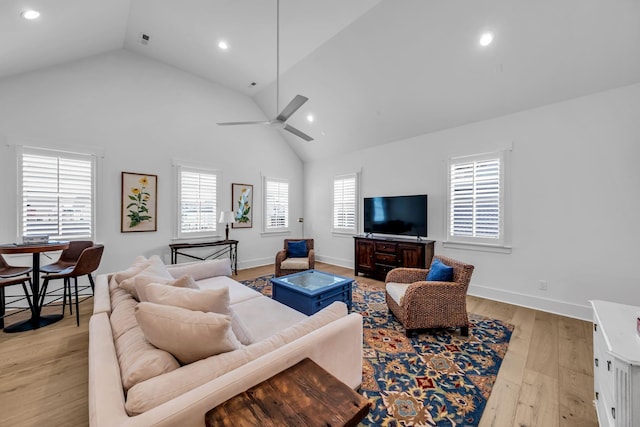 living area with baseboards, high vaulted ceiling, light wood finished floors, and recessed lighting