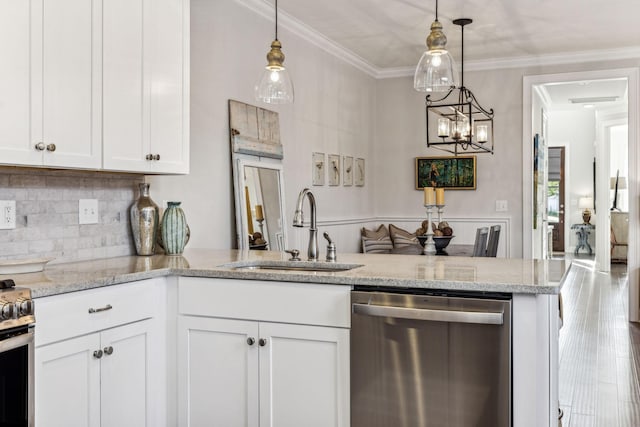 kitchen with pendant lighting, appliances with stainless steel finishes, ornamental molding, white cabinets, and a sink