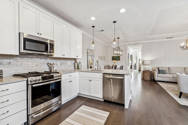 kitchen with white cabinets, appliances with stainless steel finishes, open floor plan, and hanging light fixtures