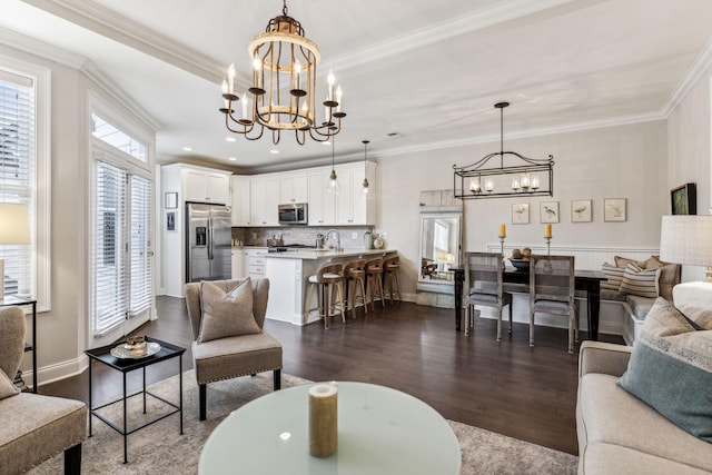 living area featuring crown molding, dark wood-type flooring, a raised ceiling, and an inviting chandelier