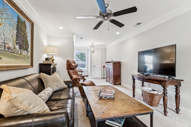 carpeted living room with baseboards, visible vents, a ceiling fan, and ornamental molding