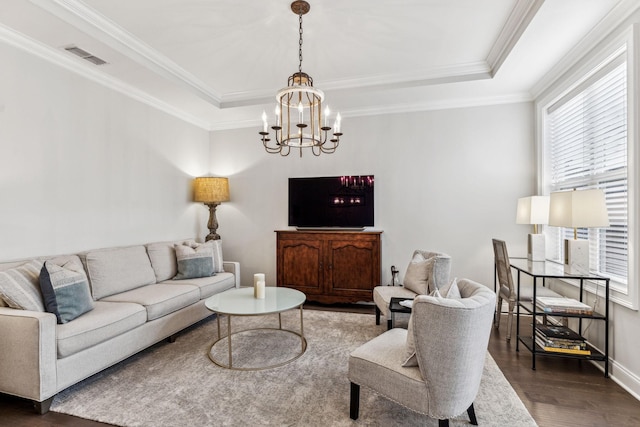 living area with ornamental molding, a tray ceiling, dark wood finished floors, and visible vents