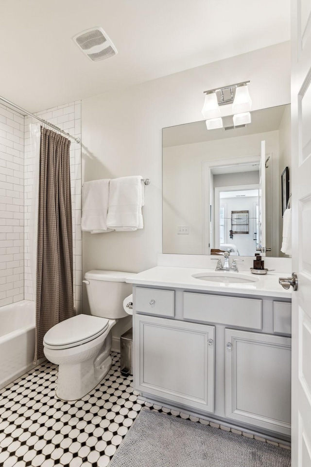 full bathroom featuring toilet, shower / bath combo, visible vents, and vanity