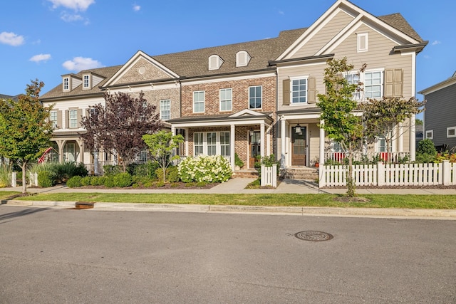 view of front of property with a fenced front yard and brick siding