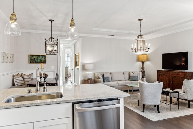 kitchen with open floor plan, a sink, hanging light fixtures, and stainless steel dishwasher