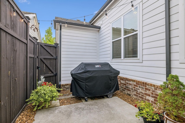 view of patio featuring grilling area, fence, and a gate