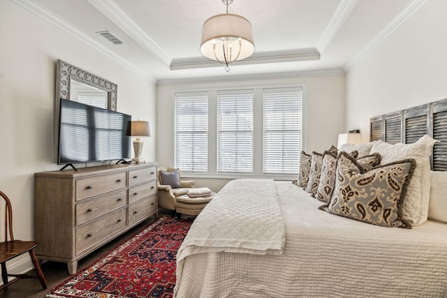 bedroom with dark colored carpet, a raised ceiling, visible vents, and crown molding