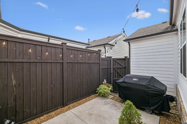 view of patio / terrace featuring area for grilling, fence, and a gate