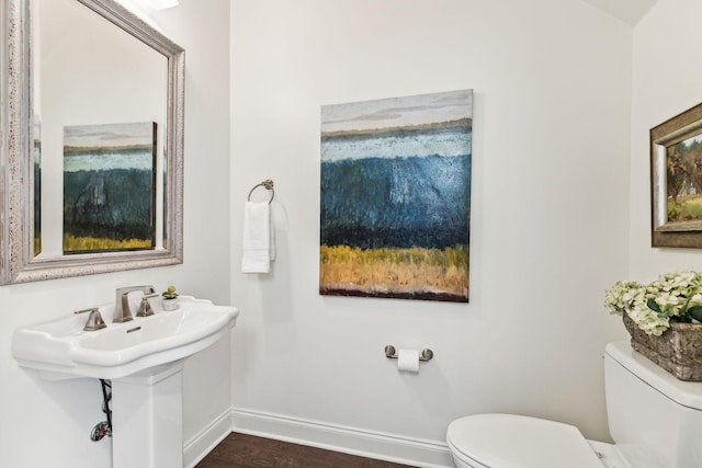 bathroom featuring toilet and baseboards