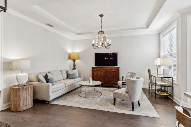 living room featuring a tray ceiling, dark wood-style flooring, visible vents, and crown molding