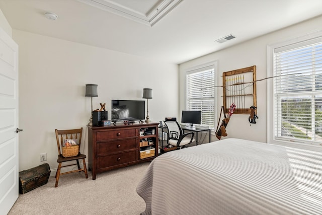 bedroom with multiple windows, visible vents, and light colored carpet