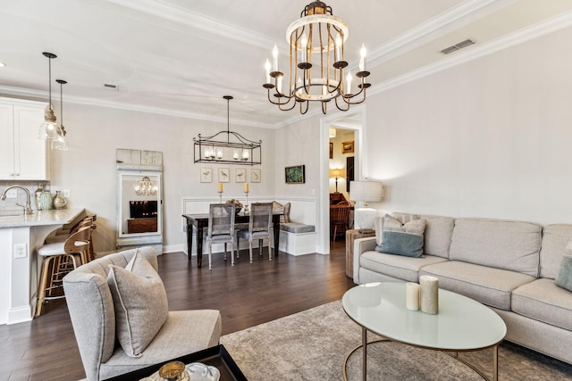 living room featuring dark wood-type flooring, visible vents, and crown molding