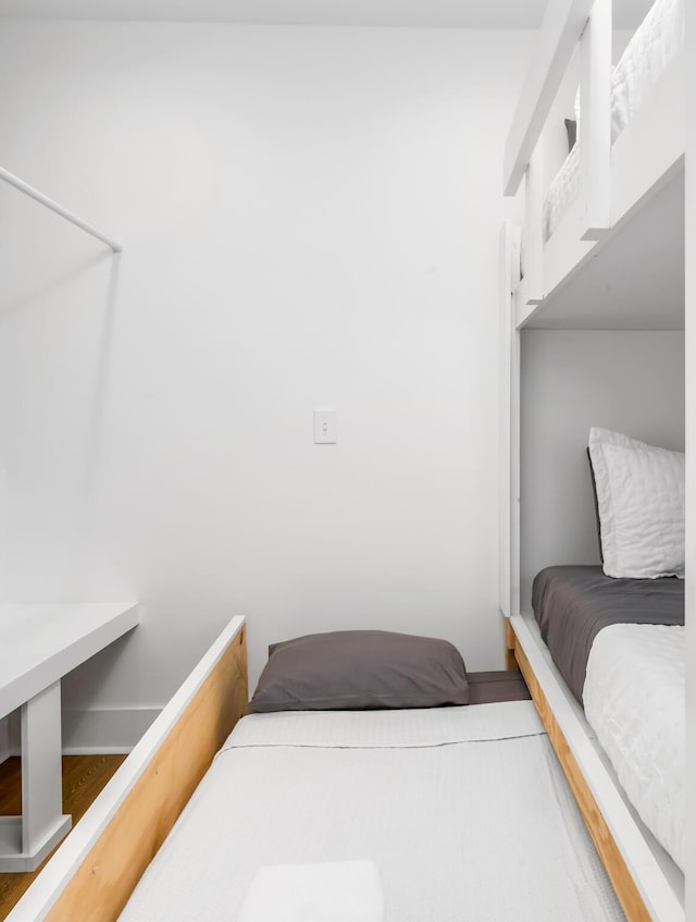 bedroom with baseboards and wood finished floors