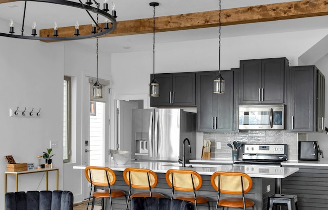 kitchen featuring a breakfast bar area, stainless steel appliances, light countertops, beam ceiling, and pendant lighting