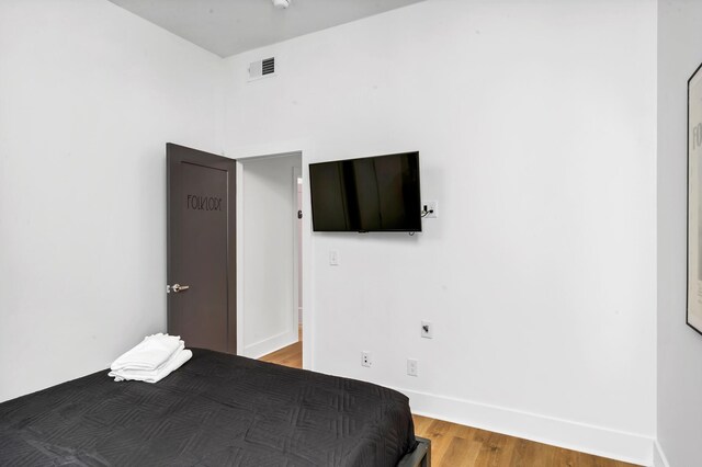 unfurnished bedroom with wood finished floors, visible vents, and baseboards