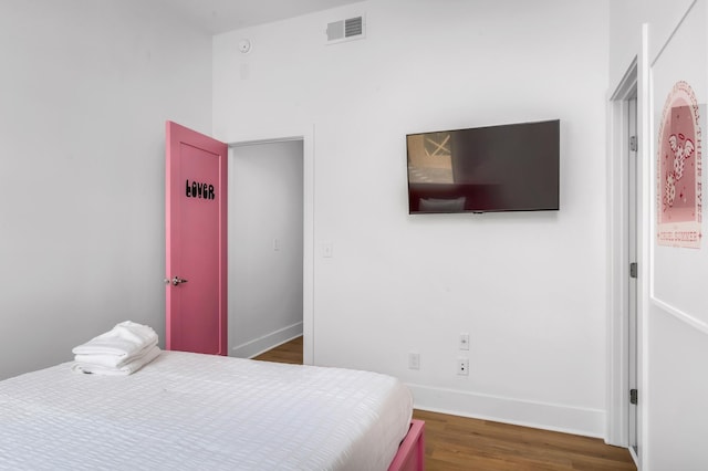 bedroom with dark wood-type flooring, visible vents, and baseboards