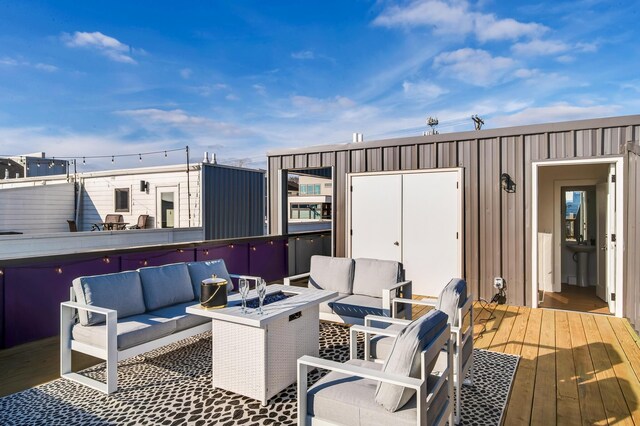 wooden deck with an outdoor living space with a fire pit