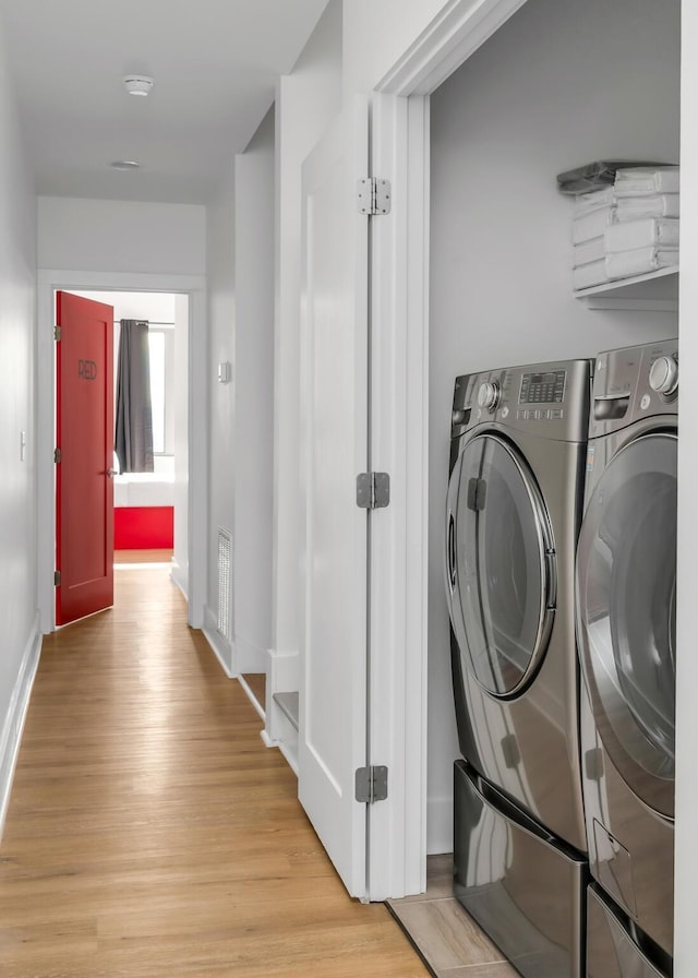 washroom featuring light wood-style floors, baseboards, laundry area, and independent washer and dryer