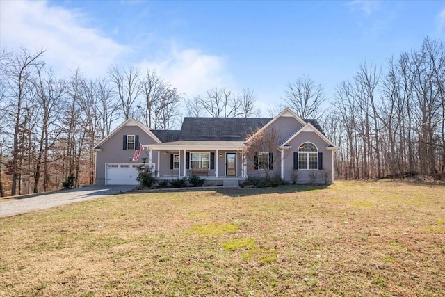 view of front facade with covered porch, driveway, a front yard, and an attached garage