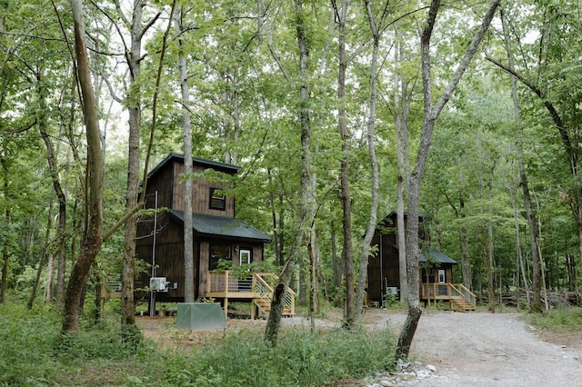 exterior space with covered porch, stairway, and metal roof