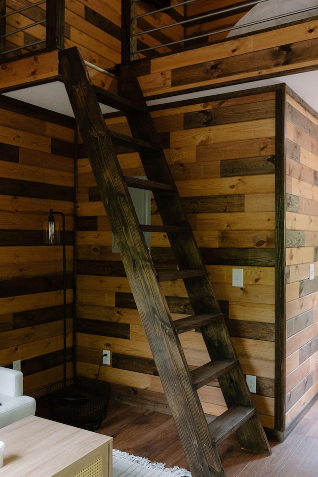 stairs featuring wood walls and wood finished floors