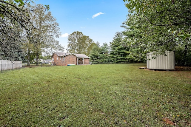 view of yard featuring a storage unit, an outdoor structure, and a fenced backyard