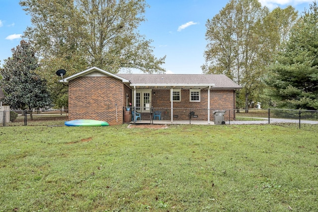 rear view of property featuring fence private yard, brick siding, a lawn, and a patio