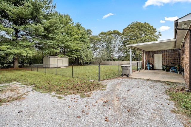 view of yard featuring a patio, fence, an outdoor structure, and a shed