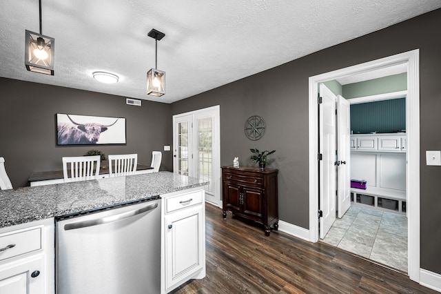 kitchen with visible vents, white cabinetry, hanging light fixtures, stainless steel dishwasher, and dark wood-style floors