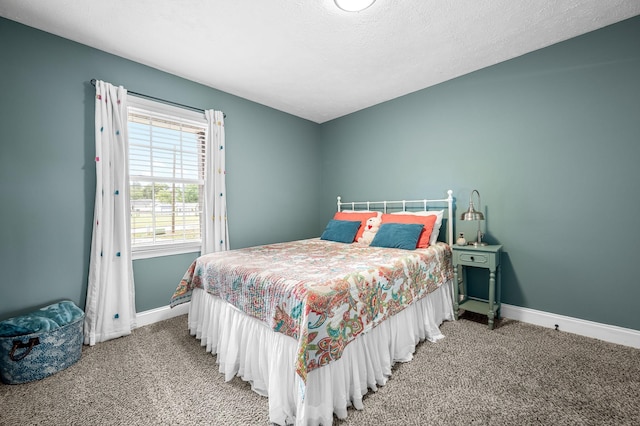 carpeted bedroom featuring a textured ceiling and baseboards