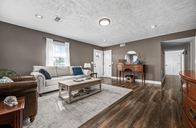 living area featuring a fireplace, dark wood finished floors, visible vents, and baseboards