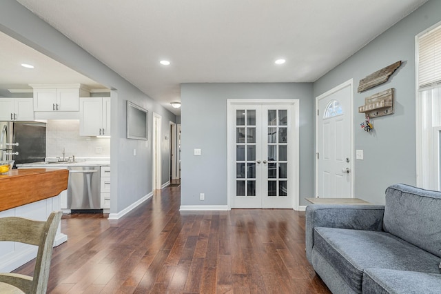 interior space featuring stainless steel appliances, open floor plan, light countertops, french doors, and dark wood finished floors